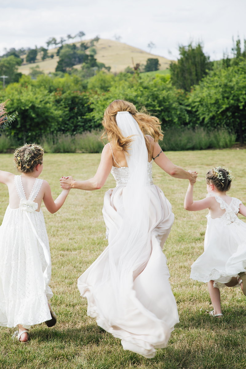Bride and flower girls skipping away